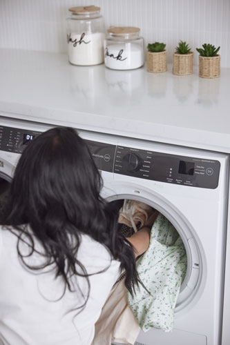 Woman putting washing into a Westinghouse Front Load washing machine